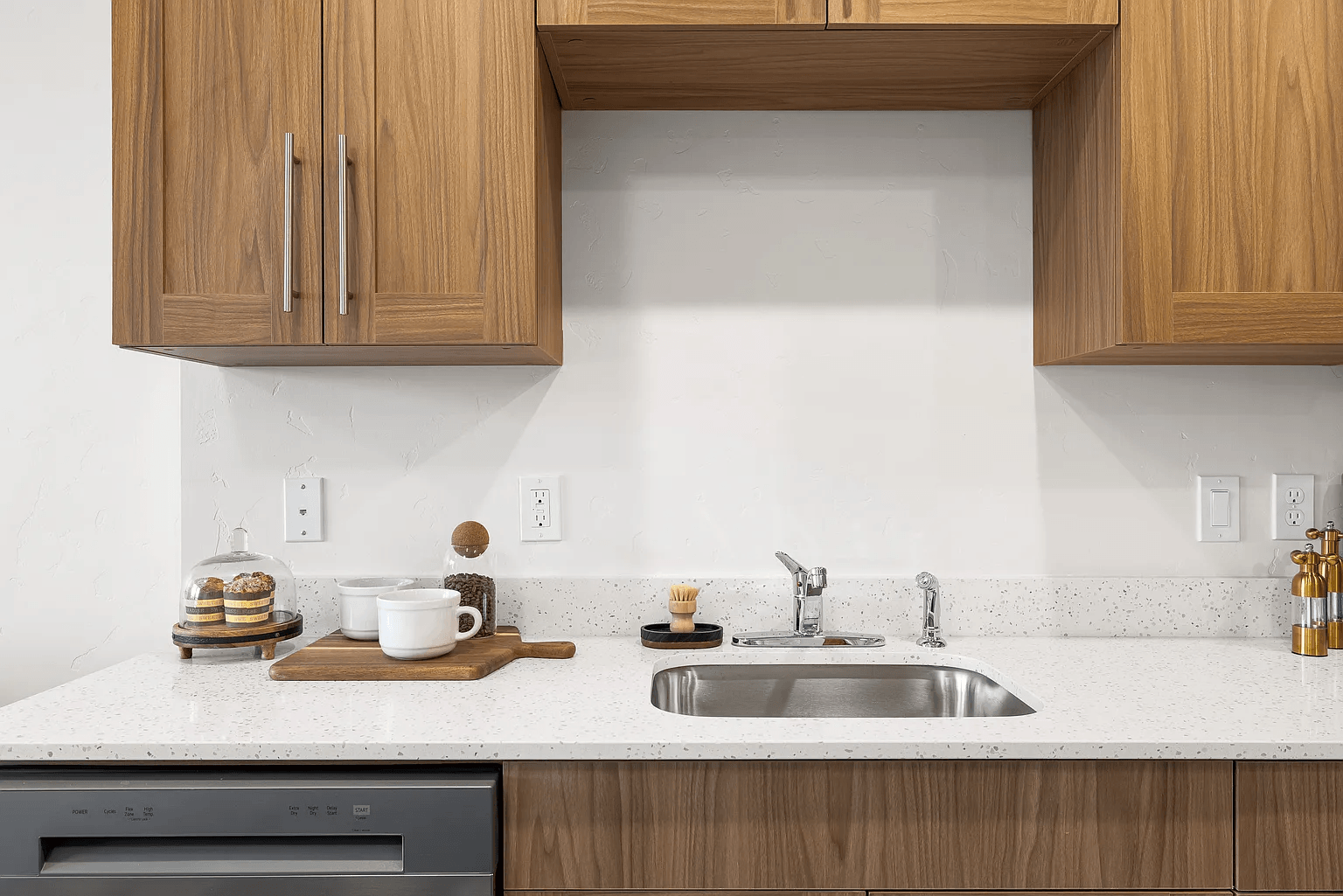 A kitchen with a sink and wooden cabinets.